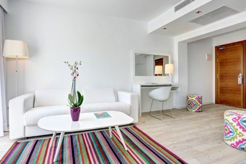 a living room filled with furniture and flowers at Grupotel Ibiza Beach Resort - Adults Only in Portinatx