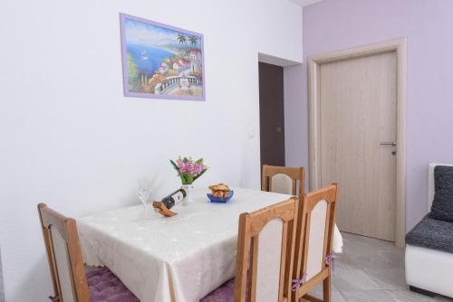 a dining room with a white table and chairs at Apartments & Rooms Seaside in Kaštela
