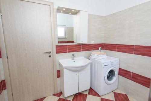 a bathroom with a washing machine and a sink at Apartments & Rooms Seaside in Kaštela