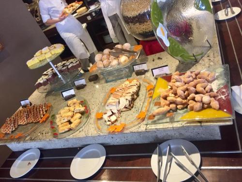 a buffet with many different types of food on display at Flat Wish Serrano Hotel in Gramado
