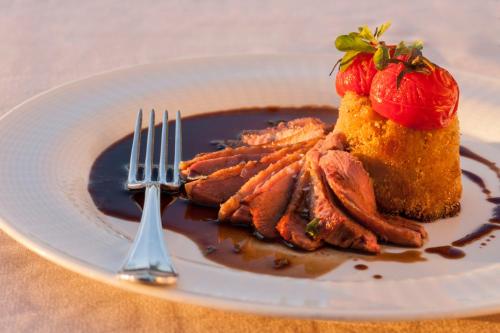 a plate of food with meat and a strawberry on it at Appartamenti nelle Vigne in Capriva del Friuli