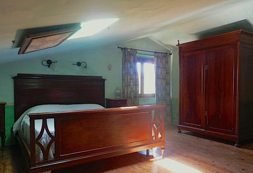 a bedroom with a wooden bed and a wooden dresser at Podere di Maggio - Casa della Nonna in Santa Fiora