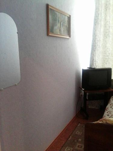 a room with a gray wall with a tv on it at EuroLux Hotel in Poltava