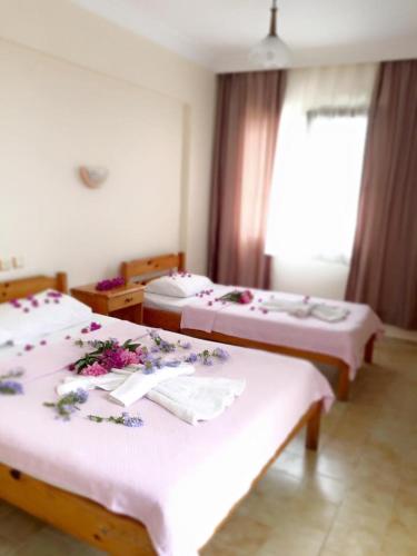 two beds in a room with flowers on them at Star Hotel in Oludeniz