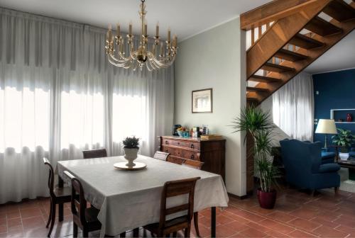 una sala da pranzo con tavolo, sedie e lampadario pendente di Casa Lunia Guesthouse a Mestre