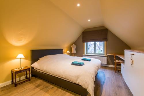 een slaapkamer met een groot bed en een raam bij Verbrand Nieuwland in Brugge
