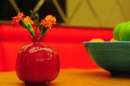 een rode vaas met bloemen er naast een kom bij Ottopera Hotel in Istanbul