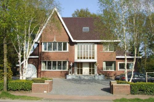 a brick house with a car parked in front of it at De Spreekkamer in Hoogstraten