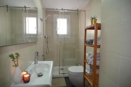 ein Bad mit einer Dusche, einem Waschbecken und einem WC in der Unterkunft RentBCN Park Guell in Barcelona