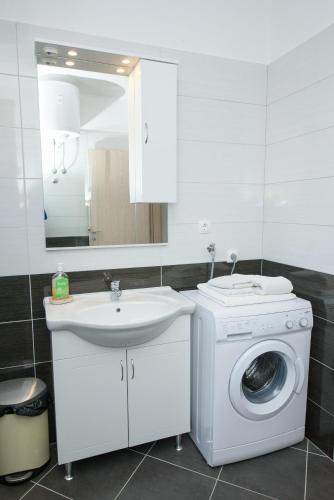 a bathroom with a washing machine and a sink at Apartments & Rooms Seaside in Kaštela