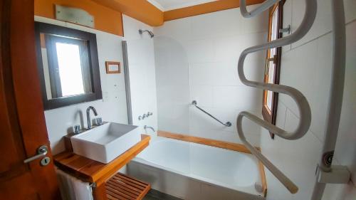 uma casa de banho com um lavatório e uma banheira em Kurtem Lodge em San Carlos de Bariloche
