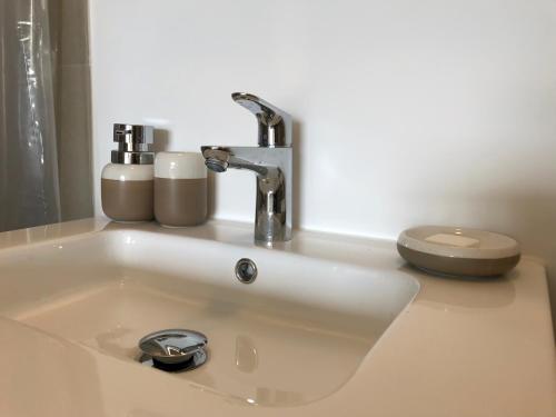 a bathroom sink with a faucet and a toilet at Waterfront Studio in Amsterdam
