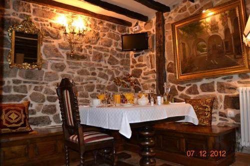 a table in a room with a stone wall at Palacio de Trasvilla in Escobedo