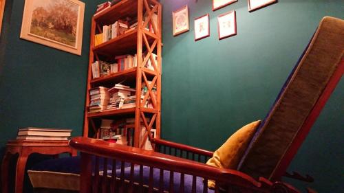 a green room with a book shelf and a chair at Schloss Gmünd in Gmünd