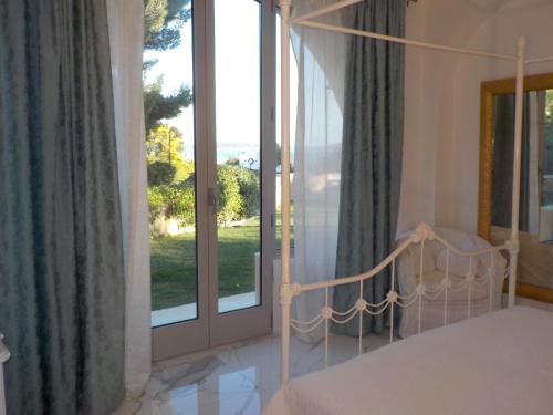 sypialnia z łóżkiem i dużym oknem w obiekcie Appartement Villa Angelina w mieście Grimaud