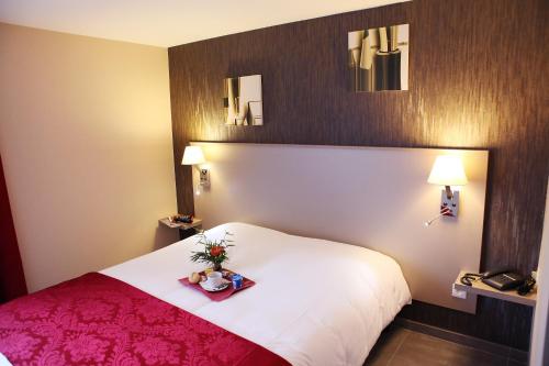 Giường trong phòng chung tại Hotel Le Coudon