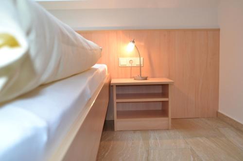 1 dormitorio con 1 cama y 1 mesa con lámpara en Beim Kahnfährmann, en Schlepzig