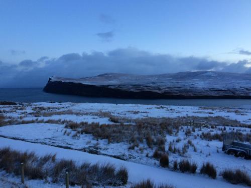 a truck parked in a field with snow on it at Pooltiel View in Milovaig