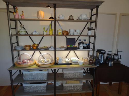 a shelf with plates and dishes on it at Hôtel des Vignes - Juliénas in Juliénas