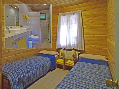 Habitación con 2 camas y baño con lavabo. en Adela y Helmut, en Cunco
