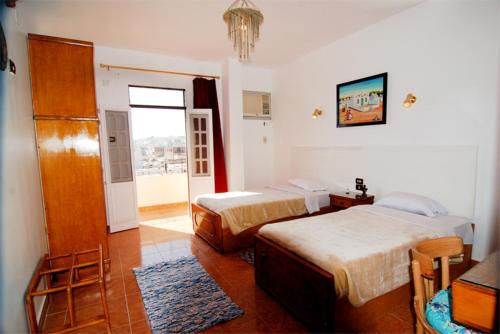 um quarto de hotel com duas camas e uma janela em Ekadolli Nubian Guesthouse Aswan em Aswan