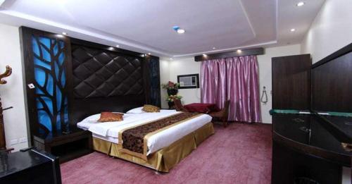 ein Schlafzimmer mit einem großen Bett mit einem großen Kopfteil in der Unterkunft Hayat Jazan Furnished Units in Dschāzān