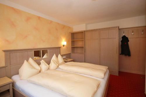 una camera con 2 letti con cuscini bianchi di Apparthaus Villa Knauer a Mayrhofen