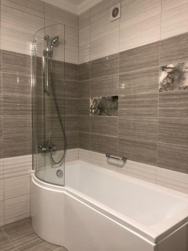 a bathroom with a bath tub with a shower at Hotel Boutique TOVMED in Vinnytsya