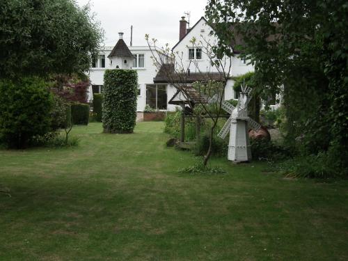 una casa con un patio con una estatua en el césped en Dove House en Cheltenham