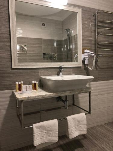 a bathroom with a sink and a mirror at Hotel Boutique TOVMED in Vinnytsya