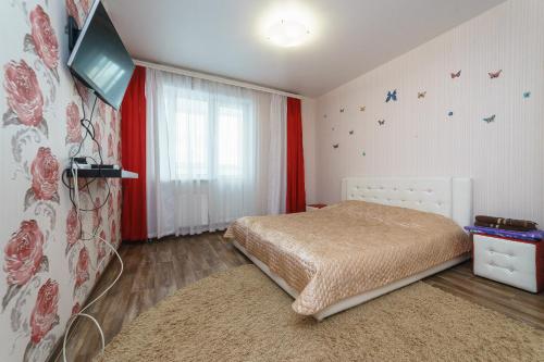 ケメロヴォにあるApartment on Pritomskiy prospektのベッドルーム1室(ベッド1台、壁にテレビ付)