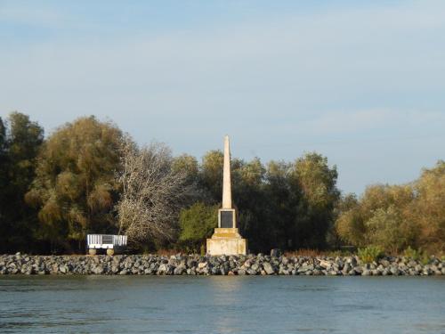 a monument on the shore of a river with a bench at Stuffino Crisan in Crisan