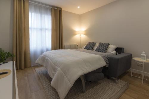 a bedroom with a large bed and a window at Apto con vistas a la catedral y aire acondicionado in Logroño