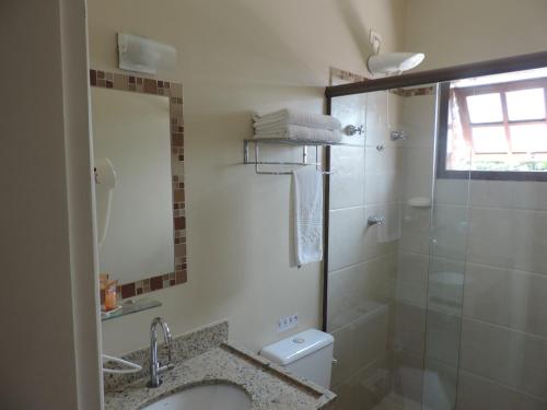 a bathroom with a shower and a sink and a toilet at Hotel Costa Balena-Piscina Aquecida Coberta in Guarujá