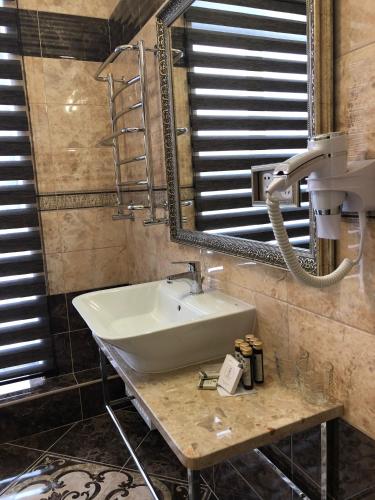a bathroom with a sink and a mirror at Hotel Boutique TOVMED in Vinnytsya