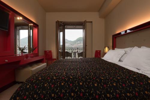 a bedroom with a large bed and a window at Lagadia 4 Seasons Hotel in Lagkadia