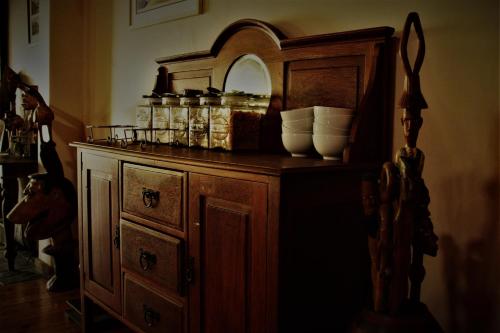 an old wooden cabinet with a mirror and jars on it at African Roots Guest House in Polokwane