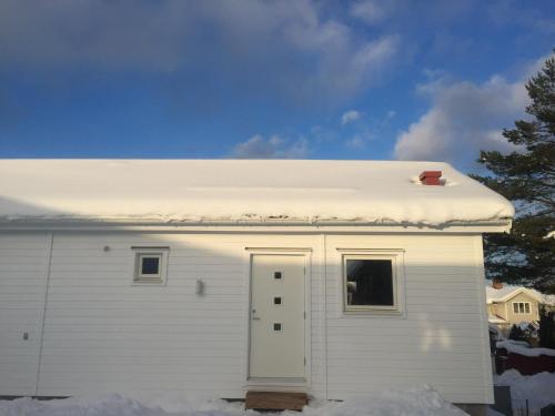 a white house with snow on the roof at Great Stay Guest House Sandviken in Sandviken