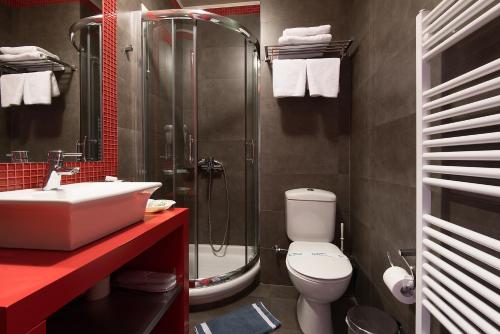 uma casa de banho com um chuveiro, um WC e um lavatório. em Lagadia 4 Seasons Hotel em Langadia