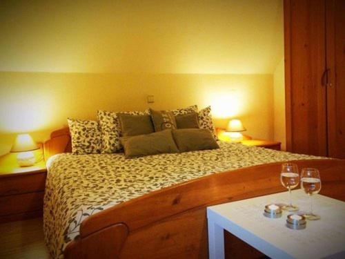 una camera con un letto e due bicchieri di vino di gostišče uh- planica a Rateče