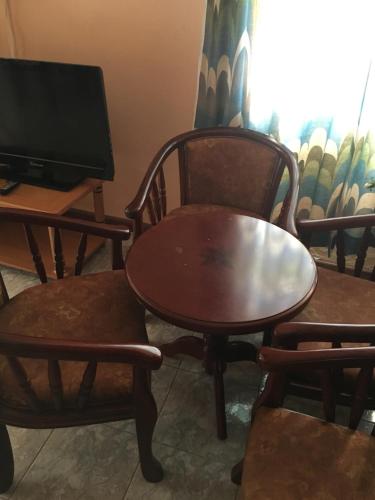 a table and two chairs and a table and a tv at Lotus Apartments in Pereybere