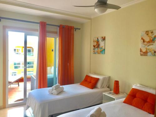 a bedroom with two beds and a balcony at Aguarii Cotillo in El Cotillo