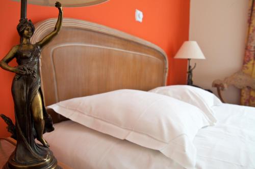 a bedroom with a bed with white pillows and a metalietyietyietyiety at Tonic Hôtel du Louvre in Paris