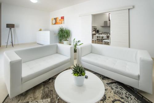 a living room with two white couches and a table at Villa Lupia in Cutrofiano