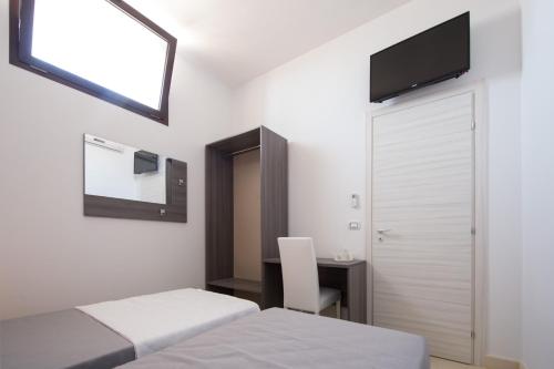 a bedroom with two beds and a desk and a mirror at Villa Lupia in Cutrofiano