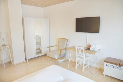 a room with a desk and a tv on the wall at F10 APARTMENTS Ulm in Ulm