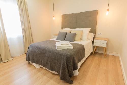 a bedroom with a bed with two towels on it at Apartamento Avenida de Colón con Aire Acondicionado in Logroño