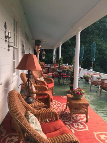 a porch with wicker chairs and a lamp on a patio at Renwick Clifton House B&B in Saugerties