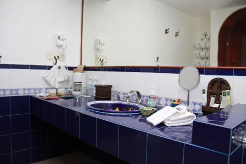 a blue bathroom counter with a sink and a mirror at Hotel La Mansion del Sol in Guadalajara
