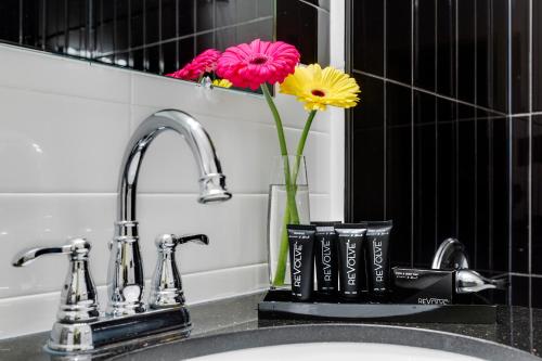 un lavabo con un jarrón con flores. en Lex Hotel NYC, en Nueva York